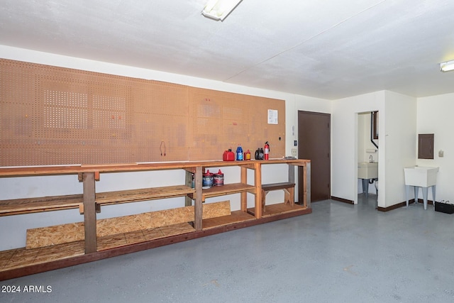 interior space featuring electric panel, sink, and a workshop area