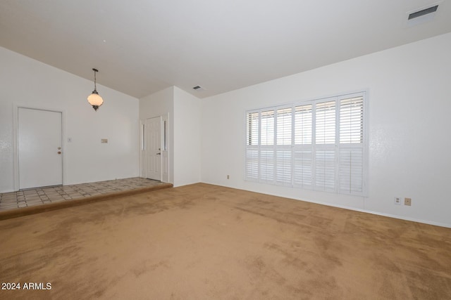 unfurnished room with carpet flooring and vaulted ceiling