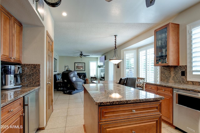 kitchen featuring backsplash, a ceiling fan, brown cabinets, and dishwasher