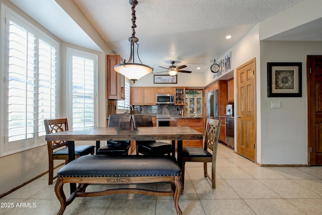 dining area featuring baseboards, plenty of natural light, and a ceiling fan
