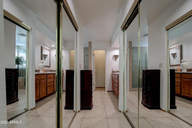 hall featuring light tile patterned floors and a sink