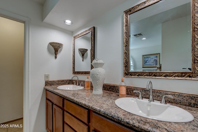 full bathroom featuring a sink, double vanity, and visible vents