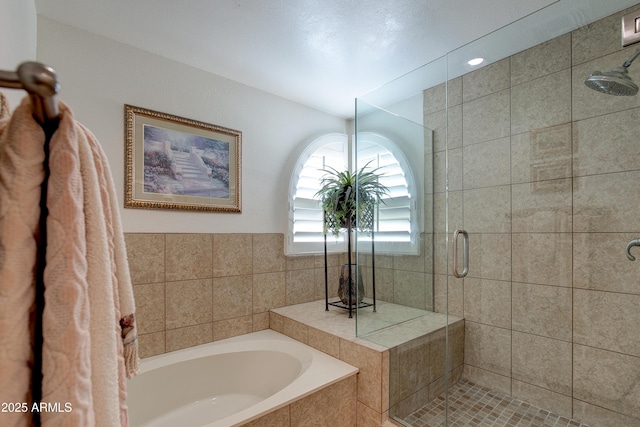bathroom with a shower stall and a garden tub