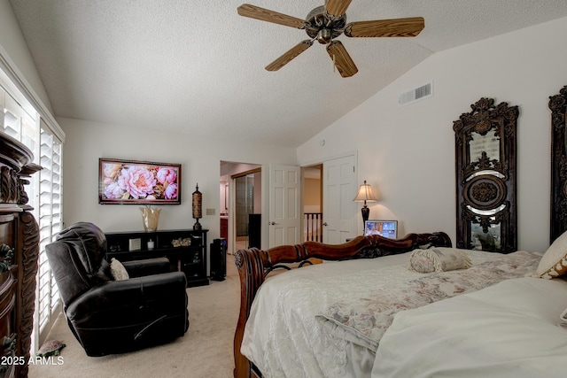 carpeted bedroom featuring a ceiling fan, lofted ceiling, a textured ceiling, and visible vents