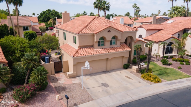 mediterranean / spanish-style house with an attached garage, stucco siding, a chimney, and a tile roof