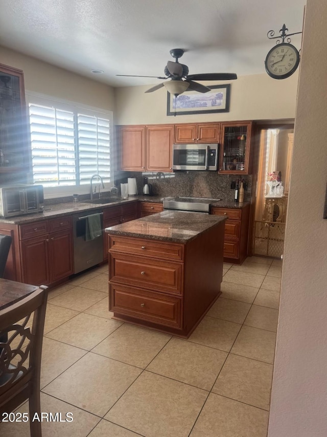 kitchen featuring decorative backsplash, a toaster, ceiling fan, a sink, and appliances with stainless steel finishes