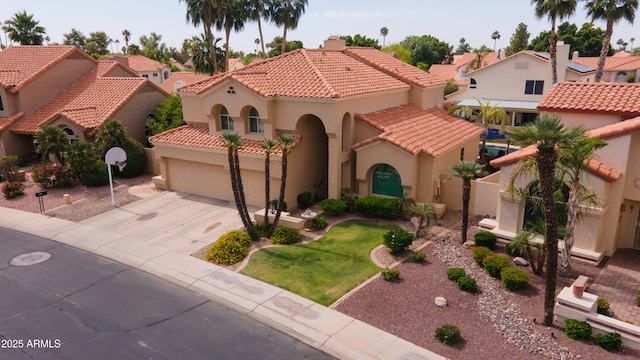 mediterranean / spanish house with a residential view, stucco siding, concrete driveway, and a tile roof