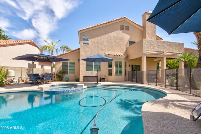 view of pool featuring ceiling fan, a patio area, fence, and a pool with connected hot tub