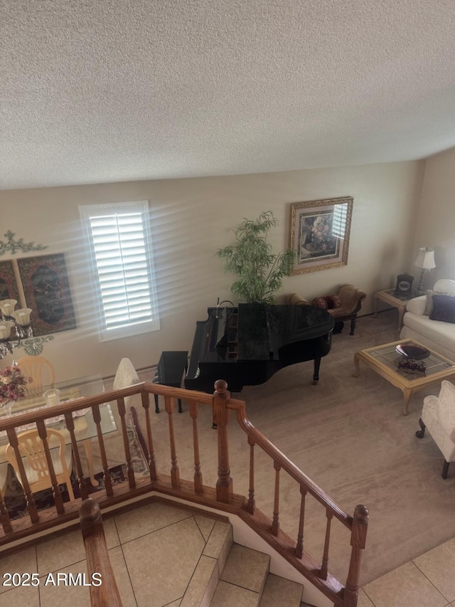living area featuring tile patterned floors, carpet floors, and a textured ceiling