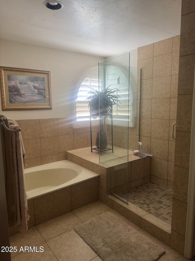 full bath with tile patterned floors, a shower stall, and a garden tub