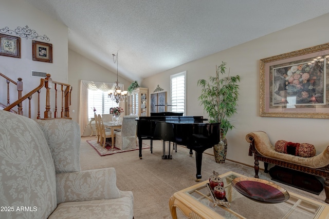 sitting room with an inviting chandelier, a textured ceiling, carpet, vaulted ceiling, and visible vents