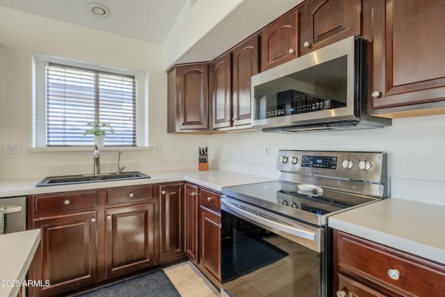 kitchen with stainless steel appliances, light countertops, and a sink