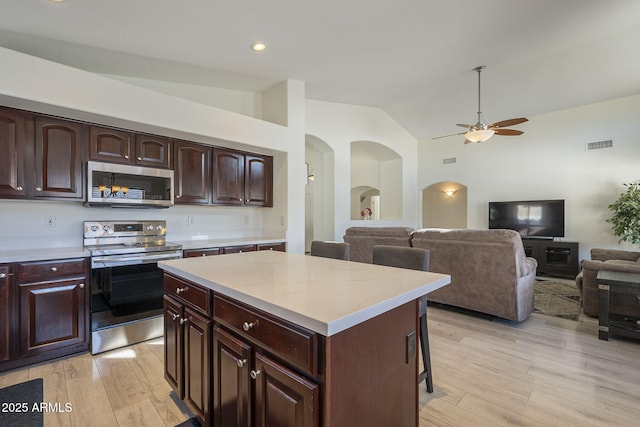 kitchen with stainless steel appliances, light wood finished floors, light countertops, and visible vents