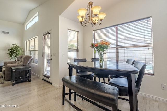 dining area with a healthy amount of sunlight, visible vents, vaulted ceiling, and an inviting chandelier