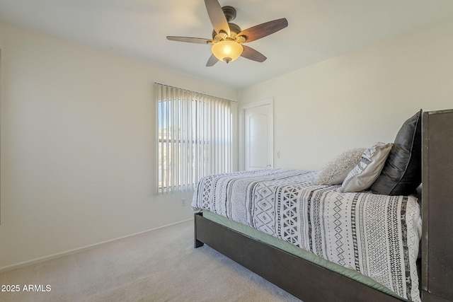 carpeted bedroom with ceiling fan and baseboards