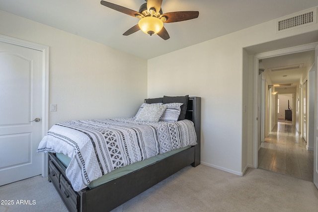 carpeted bedroom with a ceiling fan, visible vents, and baseboards