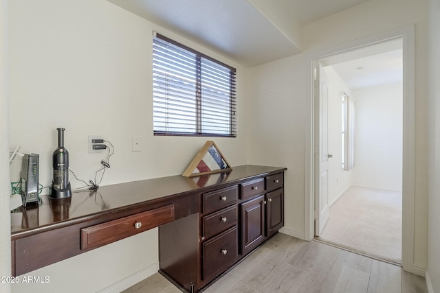 interior space featuring light wood-type flooring and baseboards