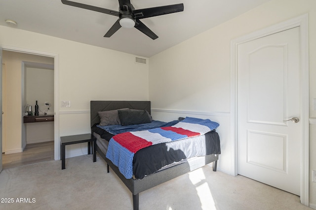 bedroom featuring light carpet, visible vents, and a ceiling fan