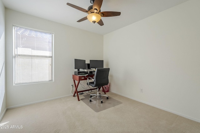 carpeted office featuring a ceiling fan and baseboards