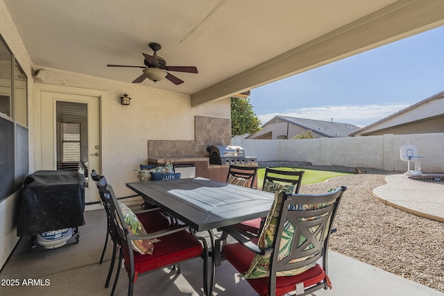 view of patio with fence, outdoor dining area, a ceiling fan, and area for grilling