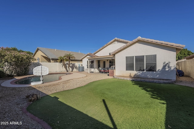 rear view of property with a fenced in pool, a fenced backyard, a tiled roof, a patio area, and stucco siding