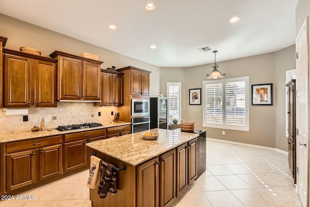 kitchen featuring a center island, light stone countertops, backsplash, and appliances with stainless steel finishes