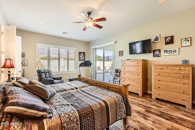 bedroom with access to exterior, hardwood / wood-style floors, multiple windows, and ceiling fan