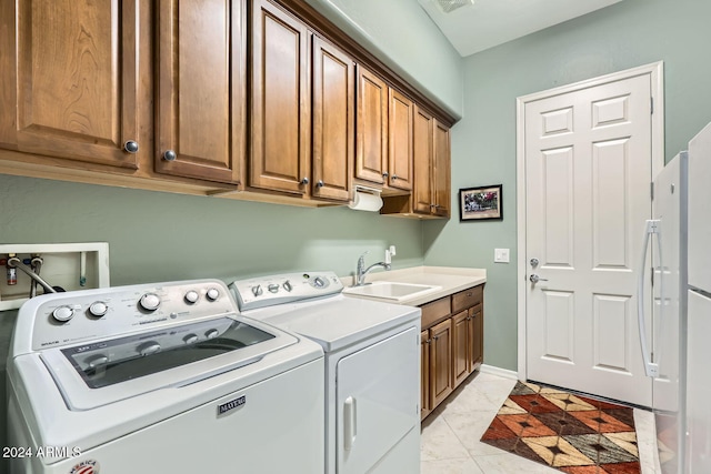 washroom with separate washer and dryer, sink, light tile patterned floors, and cabinets