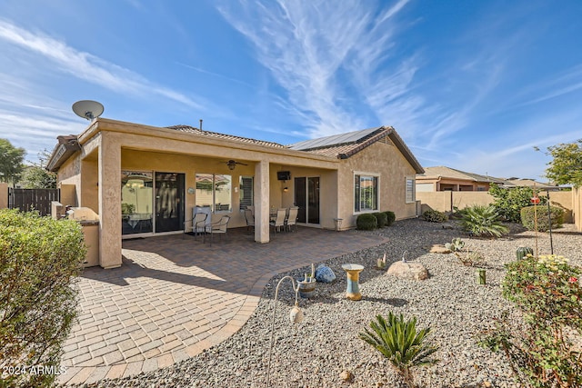 back of house featuring ceiling fan, a patio, and solar panels