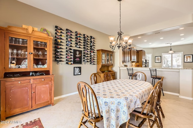 tiled dining space featuring an inviting chandelier