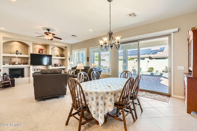 dining room featuring built in features, light tile patterned floors, and ceiling fan with notable chandelier