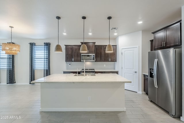 kitchen with stainless steel appliances, visible vents, a sink, and dark brown cabinets