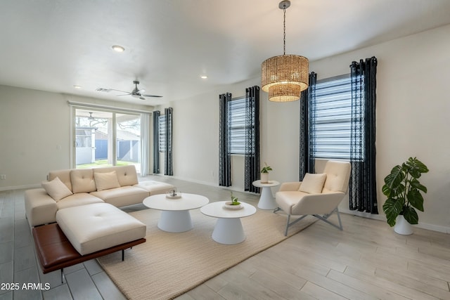 living area with a ceiling fan, recessed lighting, baseboards, and wood finished floors