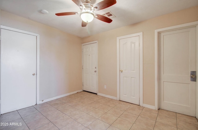 unfurnished bedroom with light tile patterned flooring and ceiling fan