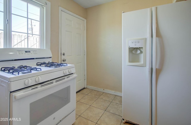 kitchen featuring light tile patterned flooring, white cabinets, and white appliances