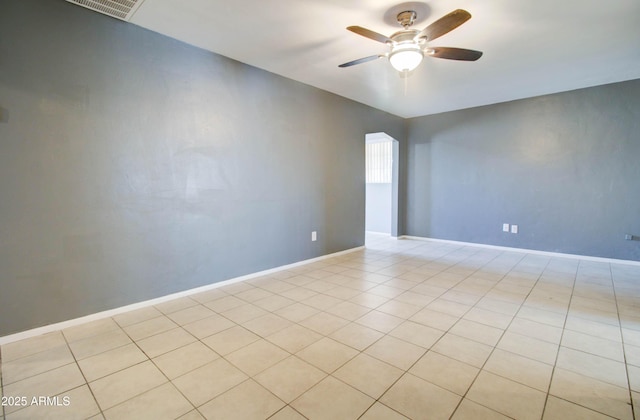 tiled empty room featuring ceiling fan