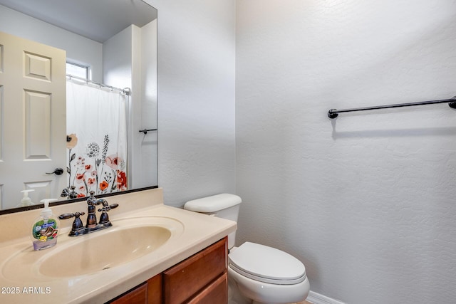 bathroom with vanity, curtained shower, and toilet