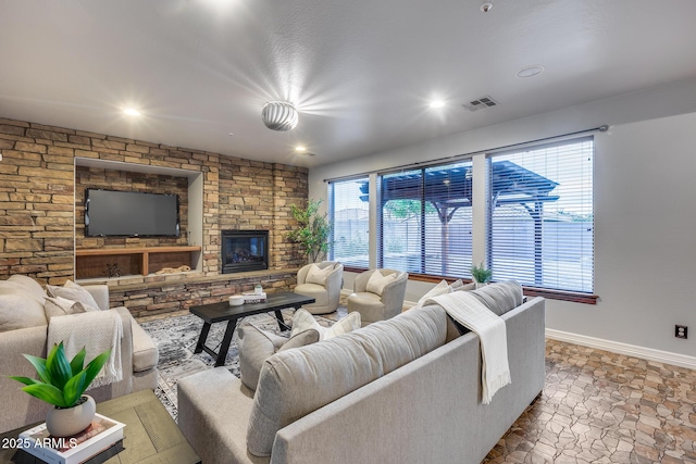 living room featuring a stone fireplace