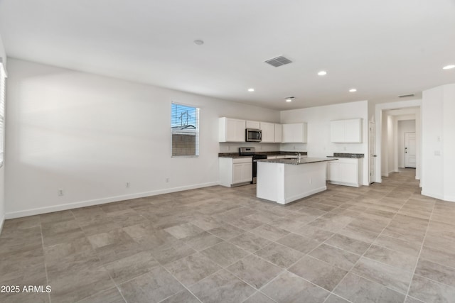 kitchen with white cabinets, sink, stainless steel appliances, and an island with sink