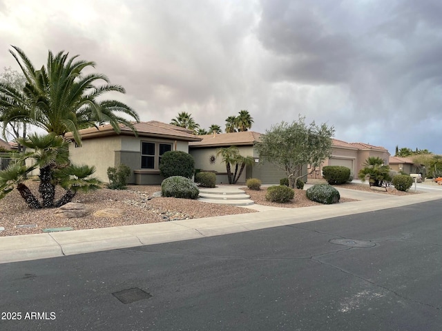 view of front of house with stucco siding, driveway, and a garage