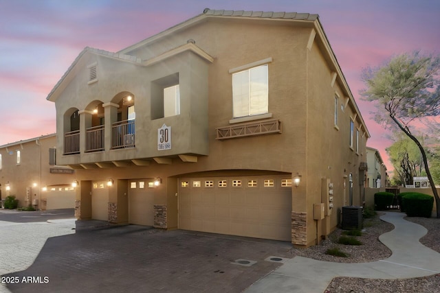 view of front of home with a garage and central air condition unit