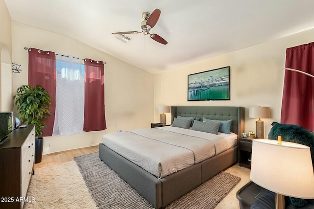 bedroom featuring ceiling fan, vaulted ceiling, and light hardwood / wood-style flooring