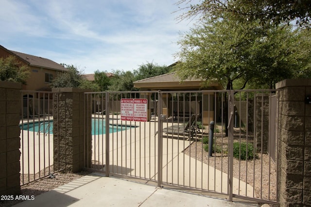 view of gate featuring a community pool