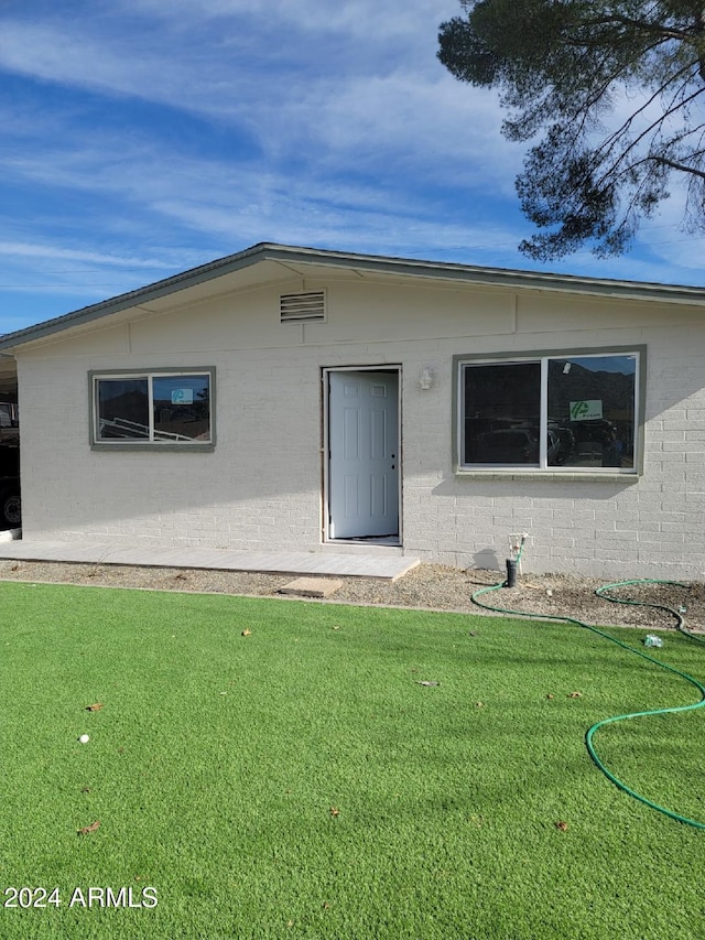 doorway to property with a lawn