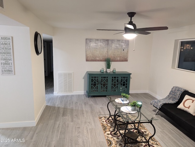 living room featuring ceiling fan and light hardwood / wood-style floors