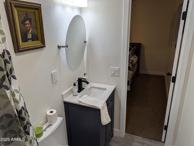 bathroom featuring toilet, hardwood / wood-style flooring, and vanity