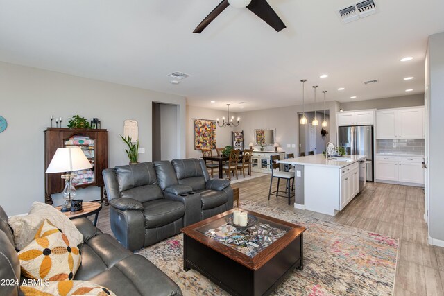 living area featuring ceiling fan and light hardwood / wood-style floors