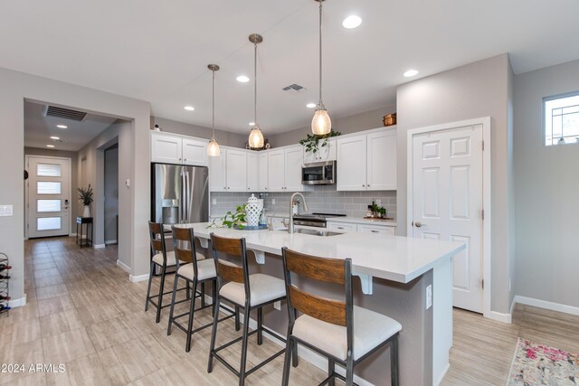 kitchen with pendant lighting, white cabinetry, a spacious island, an inviting chandelier, and a breakfast bar area