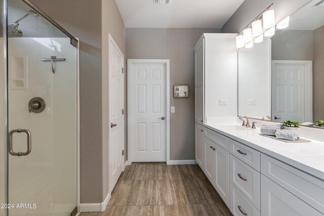 kitchen with appliances with stainless steel finishes, light stone counters, light hardwood / wood-style floors, white cabinetry, and decorative backsplash