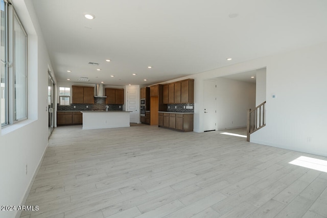 unfurnished living room with sink and light hardwood / wood-style flooring